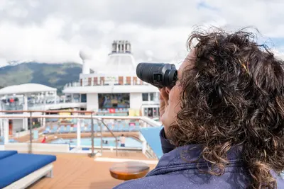 woman using binoculars on a cruise ship
