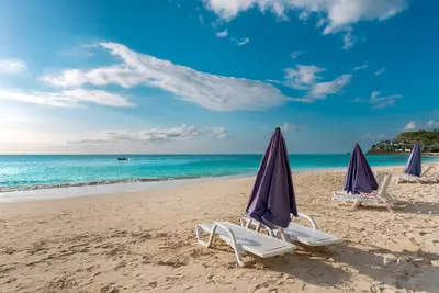 Lounge chairs with umbrellas on a beach in Antigua